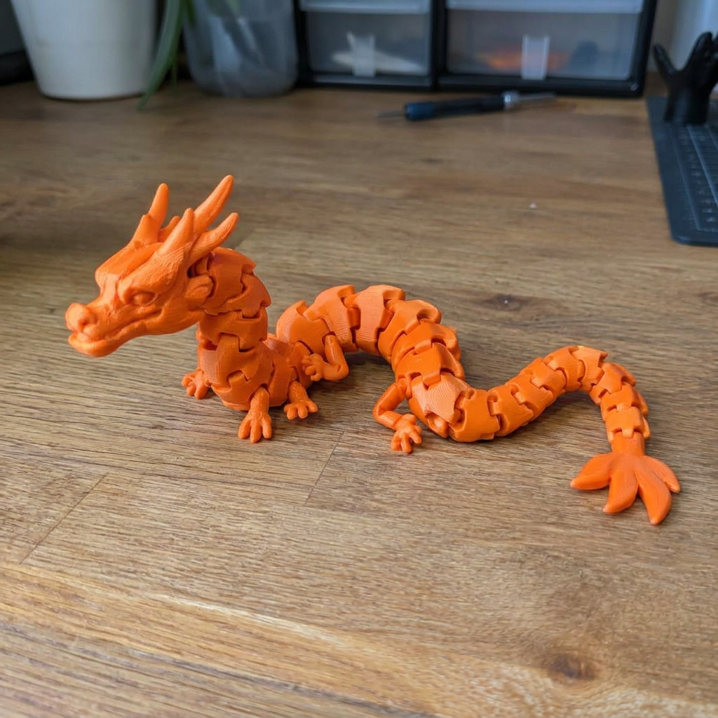 3D-geprint fidget-draakje in oranje filament
